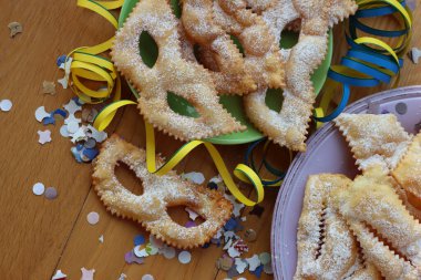 İtalyan tatlısı, kıtır kıtır, bol yağda kızartılmış ve renkli tabaklarda karnaval maskesi şeklinde şeker serpiştirilmiş. Chiacchere veya crostoli, bugie, cenci konfeti ve kağıt serpentine 