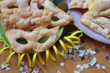 İtalyan tatlısı, kıtır kıtır, bol yağda kızartılmış ve renkli tabaklarda karnaval maskesi şeklinde şeker serpiştirilmiş. Chiacchere veya crostoli, bugie, cenci konfeti ve kağıt serpentine 