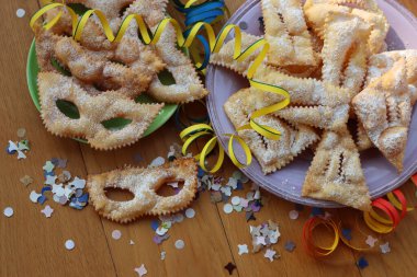 İtalyan tatlısı, kıtır kıtır, bol yağda kızartılmış ve renkli tabaklarda karnaval maskesi şeklinde şeker serpiştirilmiş. Chiacchere veya crostoli, bugie, cenci konfeti ve kağıt serpentine 