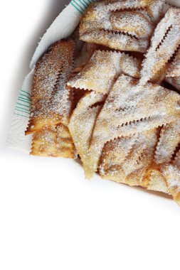 Traditional sweet crisp pastry deep-fried with powdered sugar for Carnival in a white ceramic bowl  on white background. Chiacchere or crostoli, bugie, cenci