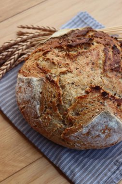 Wholegrain bread with spelt flour with linen and sunflower seeds on wooden table