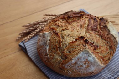Wholegrain bread with spelt flour with linen and sunflower seeds on wooden table