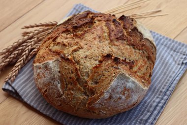 Wholegrain bread with spelt flour with linen and sunflower seeds on wooden table