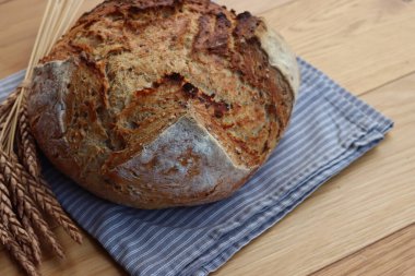 Wholegrain bread with spelt flour with linen and sunflower seeds on wooden table