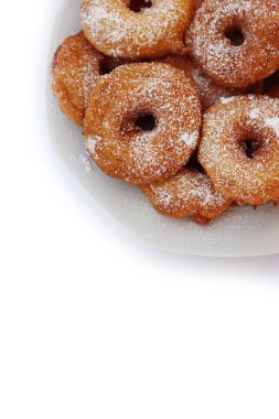 Homemade deep fried apple rings with batter sprinkled with powdered sugar on a  plate isolated on white backgrounds