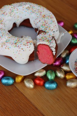 Ciaramicola 'yı bir dilimle kes. Paskalya için geleneksel İtalyan Umbrian pastası. Kırmızı donut şeklinde kek, Alchermes ile süslenmiş ve beyaz şeker ve şekerle süslenmiş.