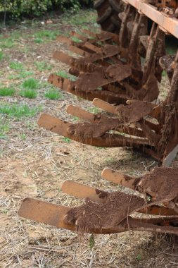 İlkbaharda tarlada toprakla kaplı traktör sabanı. Tarım endüstrisinde ekipman
