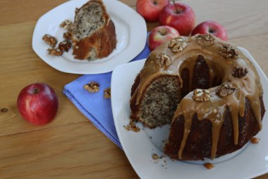 Elmalı ve Cevizli kek, karamelli ve ahşap bir tabakta bir dilim dilimlenmiş.
