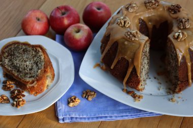 Elmalı ve Cevizli kek, karamelli ve ahşap bir tabakta bir dilim dilimlenmiş.