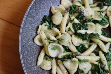 Orecchiette alla pugliese. Kızartma tavasında turp yeşili yapraklı geleneksel İtalyan makarnası.