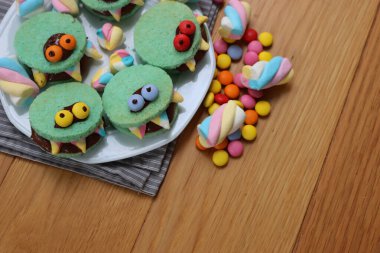 Çikolata kremalı ve şekerli çok renkli dişli canavar kurabiyeleri. Fotokopi alanı olan Cadılar Bayramı