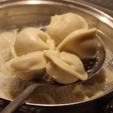 Kaynar suda İtalyan Cappellaci makarnası pişirmeye yakın çekim.