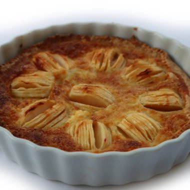 Beyaz arka planda kremalı ve dilimlenmiş meyveli ev yapımı lezzetli elmalı turta.