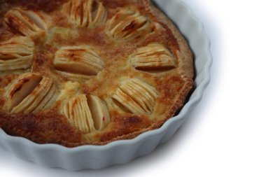 Beyaz arka planda kremalı ve dilimlenmiş meyveli ev yapımı lezzetli elmalı turta.