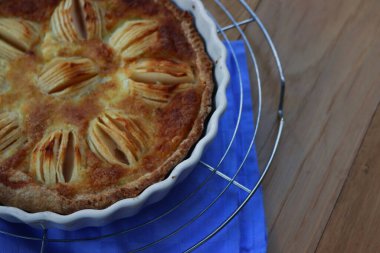 Lezzetli elmalı turta, kremalı ve dilimlenmiş meyveli ahşap masa.
