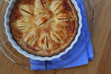 Lezzetli elmalı turta, kremalı ve dilimlenmiş meyveli ahşap masa.