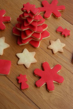 Yıldız şeklindeki kısayol kurabiyelerden yapılmış Noel ağacı kırmızı şeker jöleli ve ahşap masadaki diğer kurabiyeler. Noel arkaplanı