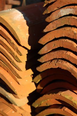 Eski kırmızı kiremitlerden yapılmış yığının yakın çekimi. Seçici odak üzerinde terracottadan yapılmış başlıklar