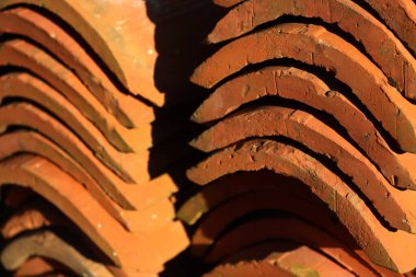 Eski kırmızı kiremitlerden yapılmış yığının yakın çekimi. Seçici odak üzerinde terracottadan yapılmış başlıklar