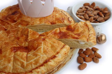 Dilimlenmiş Galette des Rois, beyaz arka planda izole edilmiş badem kremalı geleneksel Fransız pastası. Epifani keki..