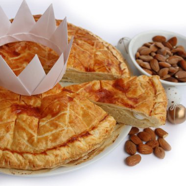 Dilimlenmiş Galette des Rois, beyaz arka planda izole edilmiş badem kremalı geleneksel Fransız pastası. Epifani keki..