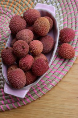 Lychee ya da Litchi, ahşap masada pembe bir porselen kasede.