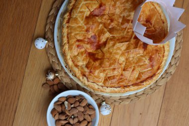 Galette des Rois, geleneksel badem kremalı Fransız pastası ve ahşap masa süsleri. Epifani keki.