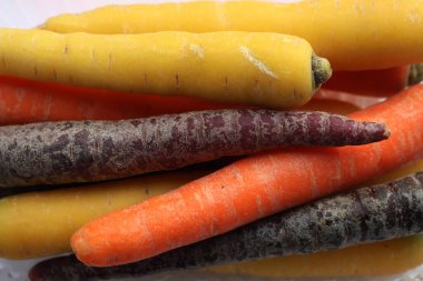 Beyaz arka planda farklı renkte havuç çeşitleri var. Organik sağlıklı gökkuşağı havuçları 