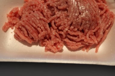 Beyaz plastik bir kutuda kıymalı et yakın plan. Pişmemiş kırmızı kıyma porsiyonu
