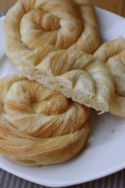 Tahta masadaki tabakta peynirle dolu börekler.