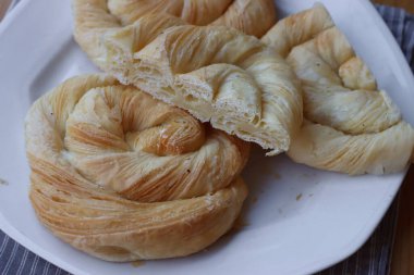 Tahta masadaki tabakta peynirle dolu börekler.