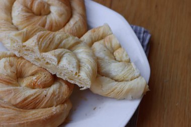 Tahta masadaki tabakta peynirle dolu börekler.