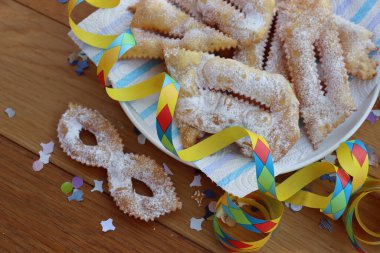 İtalyan tatlısı, kıtır kıtır, bol yağda kızartılmış ve karnaval maskesi şeklinde şeker serpiştirilmiş. Chiacchere veya crostoli, bugie, cenci konfeti ve kağıt serpentine