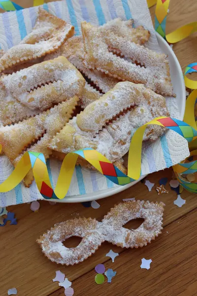 İtalyan tatlısı, kıtır kıtır, bol yağda kızartılmış ve karnaval maskesi şeklinde şeker serpiştirilmiş. Chiacchere veya crostoli, bugie, cenci konfeti ve kağıt serpentine