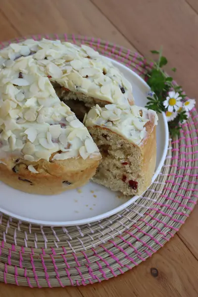 Paskalya için badem ve beyaz çikolata jölesiyle dilimlenmiş tatlı ekmek. Tahta masadaki beyaz tepside kır çiçekleriyle birlikte.