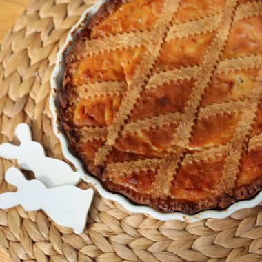 Pastiera adındaki geleneksel İtalyan paskalya pastası seramik tavşanlarla ahşap masada. 