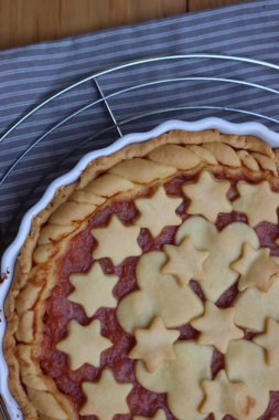 Ev yapımı şeftalili turta ya da turta, gri ve beyaz çizgili peçete, ahşap masa.  