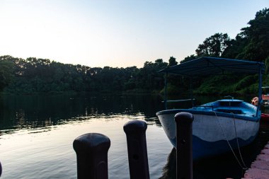 Kaptai Gölü 'nün sakin sularında huzur içinde dinlenen bağlı tekneler, sıcak öğleden sonra ışığında yıkandılar. Bu sakin manzara Bangladeş kırsalının ve göl yaşamının huzur dolu güzelliğini yansıtıyor..
