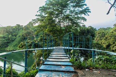Kaptai Gölü etrafındaki yemyeşil tepelik cenneti yansıtıyor ve nefes kesici bir yansıma yaratıyor. Sakin sular, yemyeşil tepeler ve dingin gökyüzü bu sakin ve el değmemiş Bangladeş manzarasının güzelliğini yakalar..