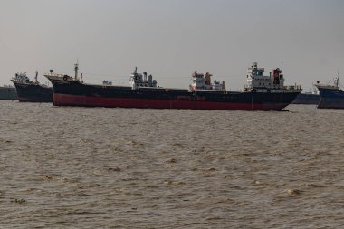 Büyük bir yük gemisi Patenga, Bangladeş yakınlarındaki okyanusta sürekli yüzüyor ve deniz ticareti ve ulaşımı gösteriyor. Uçsuz bucaksız deniz ve uzak ufuk güçlü, sakin bir deniz manzarası fotoğrafı yaratır..