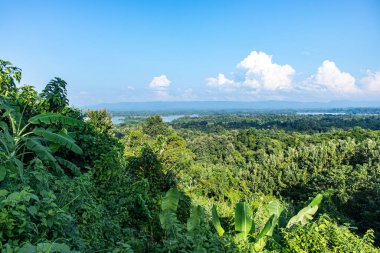 Rangamati 'nin cangıl kaplı tepeleri parlak mavi gökyüzünün altında canlı yeşillikler ve doğal güzellikler sergiliyor. Doğa, seyahat, manzara ve açık hava macera fotoğrafçılığı için mükemmel..