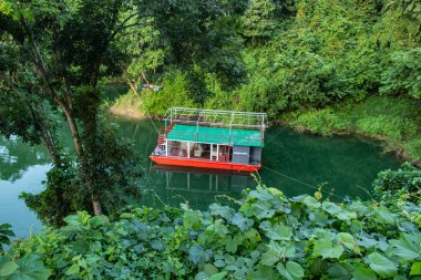 Rangamati göl kenarı teknelerinin sakin sularda birbirine bağlanmış, geleneksel ahşap kayıkları ve dingin göl yaşamını yakalayan huzurlu manzarası. Seyahat, doğa ve kültürel fotoğrafçılık temaları için mükemmel..