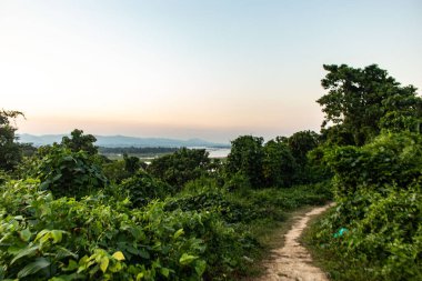 Rangamati tepesi ve göl bölgesinin manzarası sakin suları çevreleyen yemyeşil tepeleri gözler önüne seriyor. Bu huzurlu manzara Bangladeş 'in doğal cazibesini ve huzurlu kırsal atmosferini yansıtıyor..