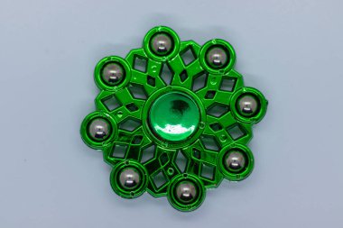 Nötr bir yüzey üzerinde ağır görev dayanakları ile dayanıklı yeşil hareketli dönen, stres rahatlama, odaklanma, duyusal oyun, farkındalık, konsantrasyon ve hem çocuklar hem de yetişkinler için eğlence amaçlı kullanım için mükemmel.