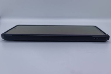 Koruyucu çantası ve ekranı olan bir akıllı telefonun yan görüntüsü. Parlak tasarım ve cihaz koruması. Teknoloji, cihaz ve seyyar stok fotoğrafçılığı için temiz beyaz bir arkaplanda izole edilmiş..