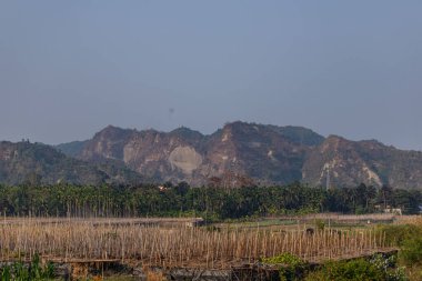 Bereketli tropikal bitki örtüsüyle çevrili uzak dağların altında manzaralı bir kırsal vadi açılır. Manzara doğal güzelliği, sakin atmosferi ve el değmemiş kırsal bölgenin cazibesini harmanlıyor..