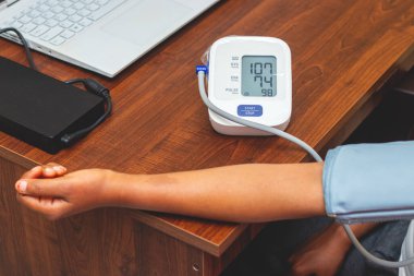 selective focus of a lady measuring blood pressure on a digital Sphygmomanometer. clipart