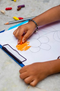 Sınıfta bir erkek bebek resim çiziyor..