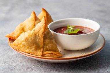 Seçici odaklı Samosa, baharatlı patates dolu hamur işi, çıtır çıtır, tuzlu, domates ve nane aromalı popüler Hint atıştırmalığı.. 