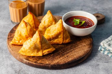Seçici odaklı Samosa, baharatlı patates dolu hamur işi, çıtır çıtır, tuzlu, domates ve nane aromalı popüler Hint atıştırmalığı.. 